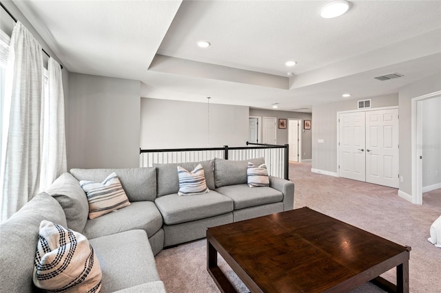 living area featuring baseboards, recessed lighting, visible vents, and light colored carpet