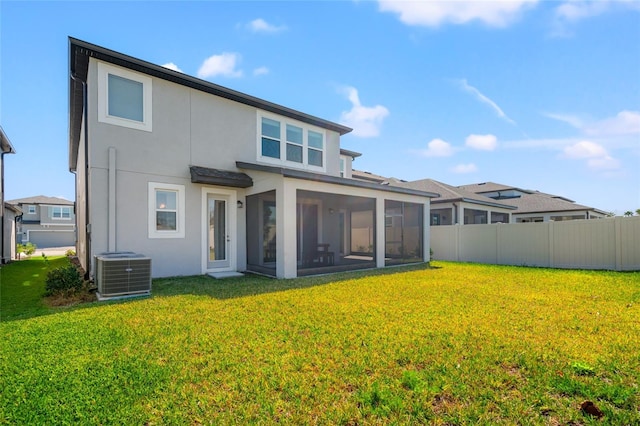 rear view of property with a yard, stucco siding, fence, and central air condition unit