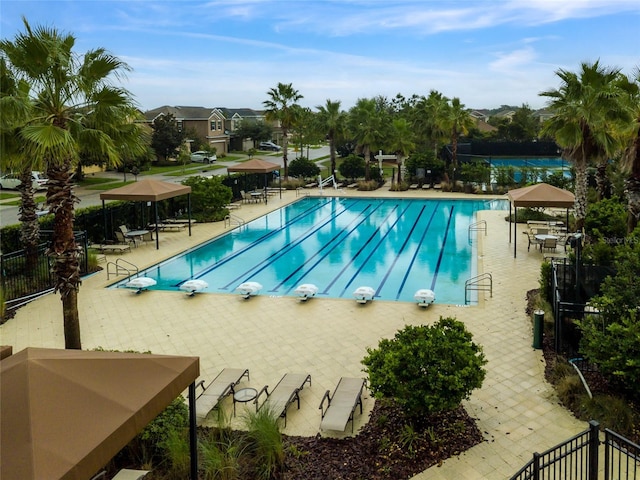 community pool featuring a diving board, a patio, a gazebo, and fence