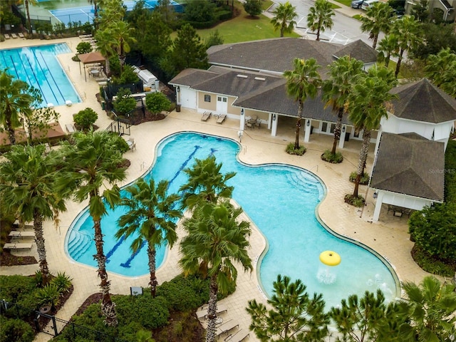 pool with a patio area and fence