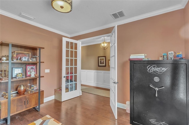 interior space featuring ornamental molding, french doors, visible vents, and wood finished floors