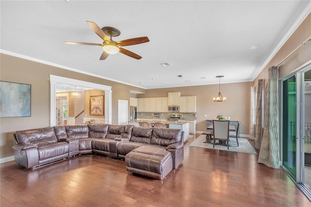 living area with ornamental molding, dark wood finished floors, and stairway