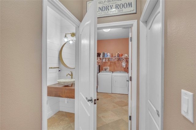 bathroom featuring a textured wall, washer and clothes dryer, and vanity