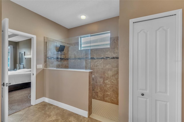 bathroom with tile patterned flooring, baseboards, ensuite bath, and a walk in shower