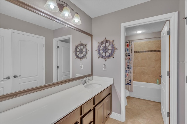 bathroom featuring tile patterned flooring, toilet, vanity, baseboards, and shower / bath combo with shower curtain