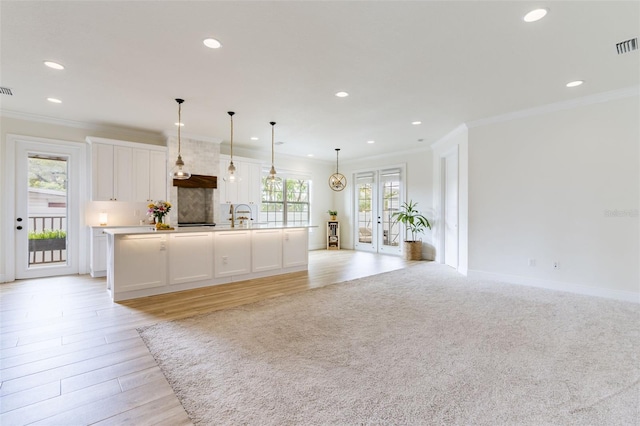 kitchen featuring tasteful backsplash, ornamental molding, white cabinets, and open floor plan