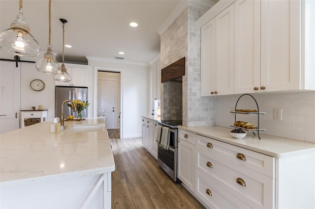 kitchen featuring a sink, appliances with stainless steel finishes, light wood-type flooring, decorative backsplash, and crown molding