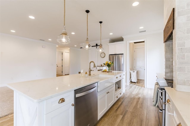 kitchen featuring appliances with stainless steel finishes, crown molding, light wood-type flooring, a sink, and recessed lighting