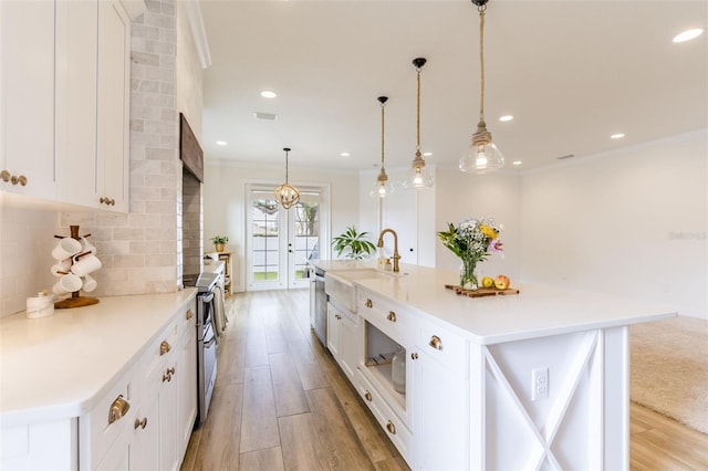 kitchen with light wood-style floors, tasteful backsplash, ornamental molding, and stainless steel appliances