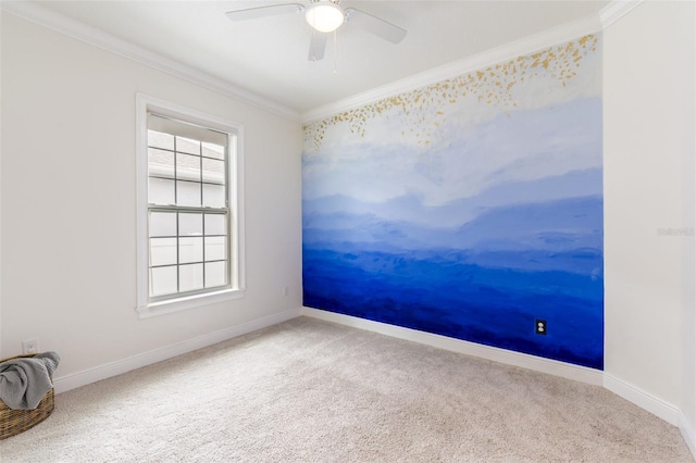 carpeted spare room featuring ornamental molding, baseboards, and a ceiling fan