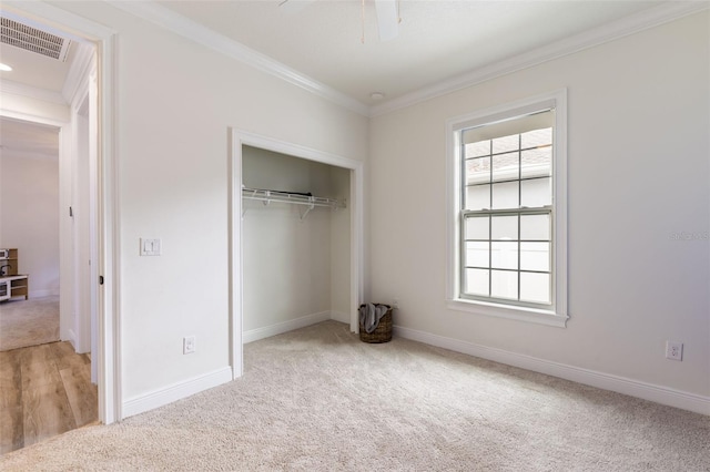 unfurnished bedroom featuring visible vents, light colored carpet, and ornamental molding