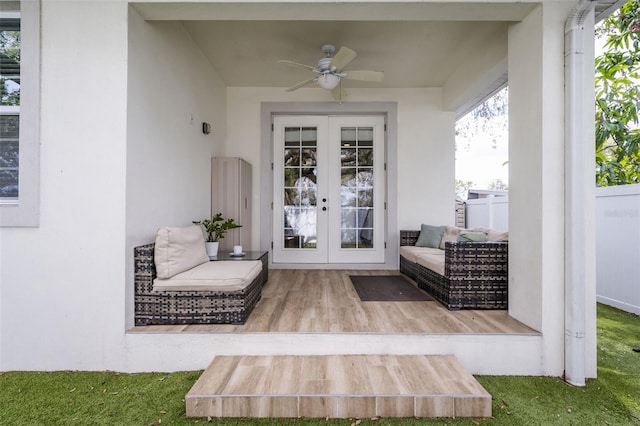 entrance to property with stucco siding, an outdoor hangout area, a ceiling fan, and french doors