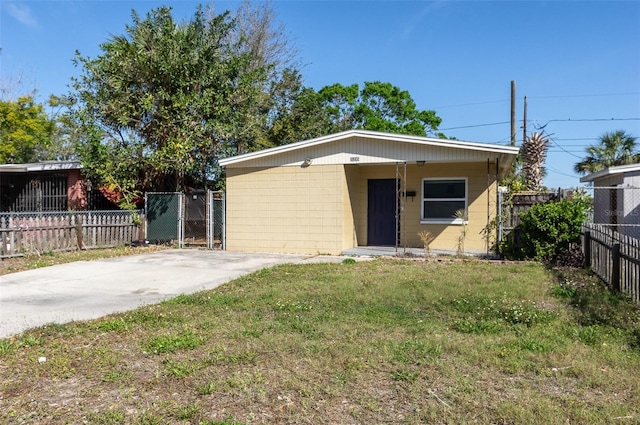 view of front of house featuring concrete driveway, a front lawn, and fence