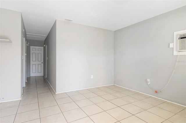 empty room with light tile patterned floors and a wall mounted AC