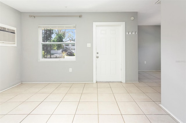 empty room with light tile patterned floors and a wall mounted air conditioner