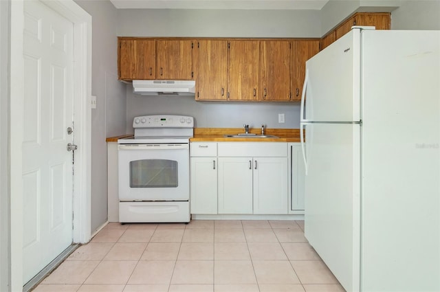 kitchen with light tile patterned floors, under cabinet range hood, white appliances, a sink, and light countertops