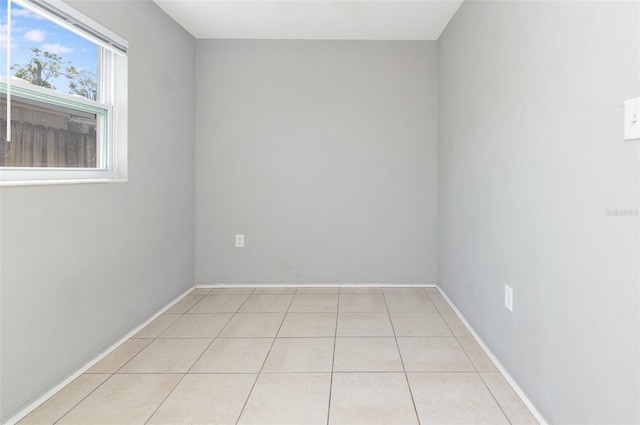 spare room with light tile patterned floors and baseboards