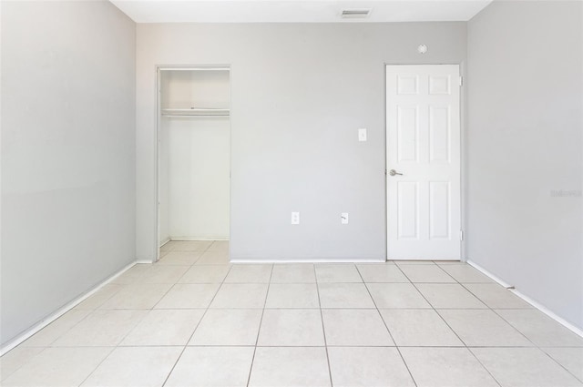 unfurnished bedroom with a closet, visible vents, and light tile patterned floors