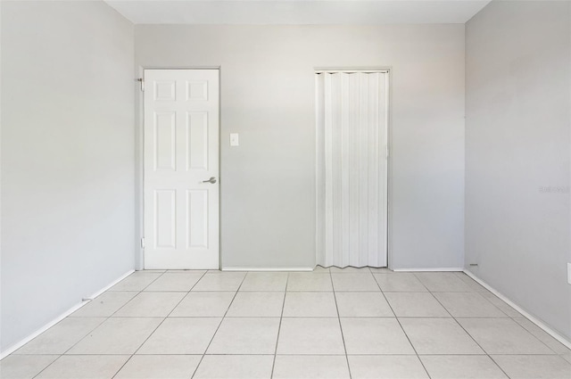 unfurnished bedroom with light tile patterned floors and a closet