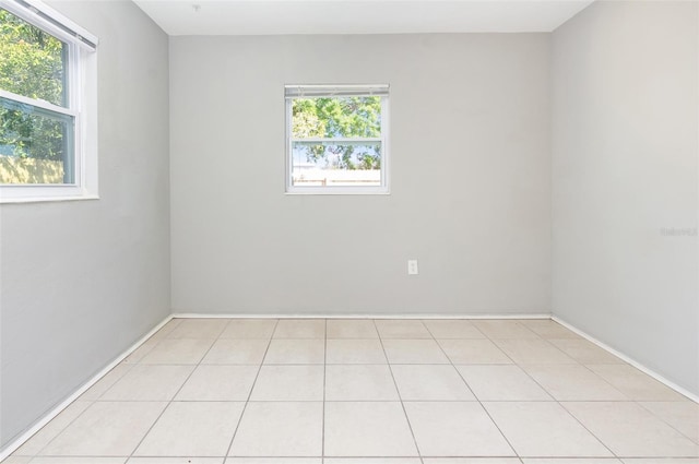 empty room with a healthy amount of sunlight and light tile patterned flooring