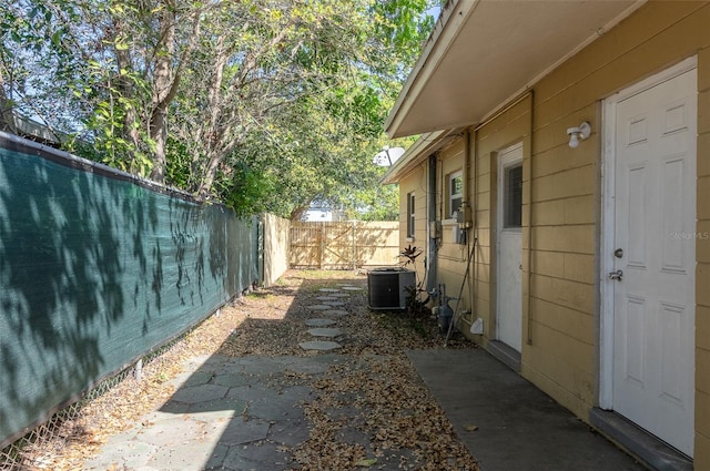 view of side of property featuring central AC unit, a patio area, and a fenced backyard