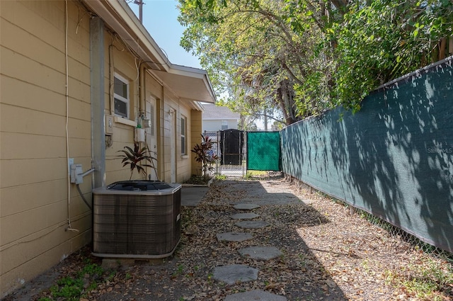 view of yard featuring fence, a gate, and central air condition unit