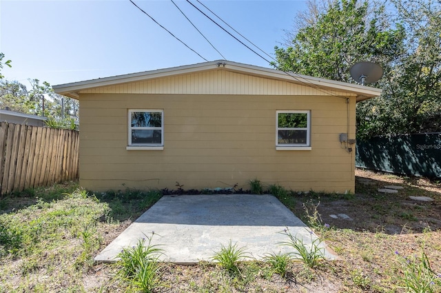 view of side of home with a patio area and fence