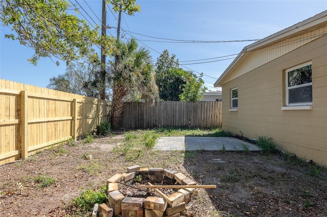 view of yard with a patio area, a fenced backyard, and a fire pit