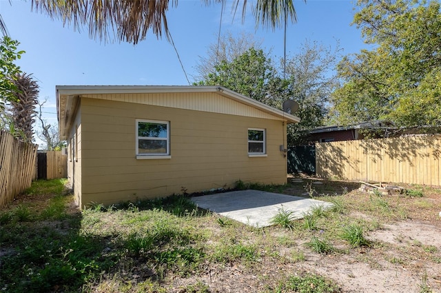 view of side of property with a fenced backyard and a patio