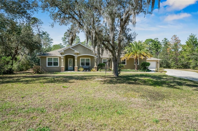 view of front of house with a garage, a front yard, concrete driveway, and stucco siding