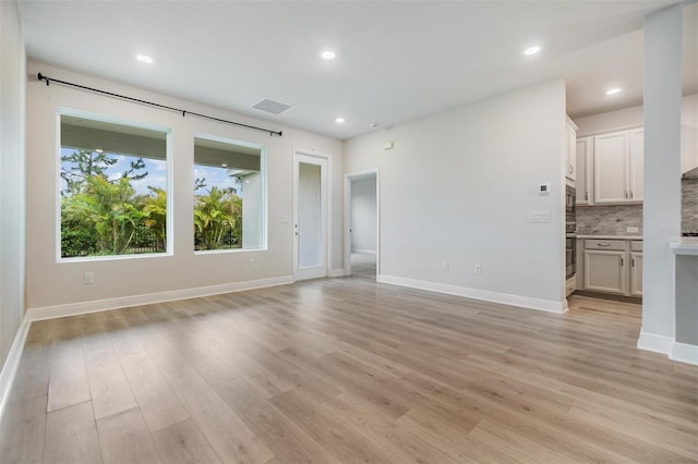 unfurnished living room with recessed lighting, visible vents, baseboards, and light wood-style floors