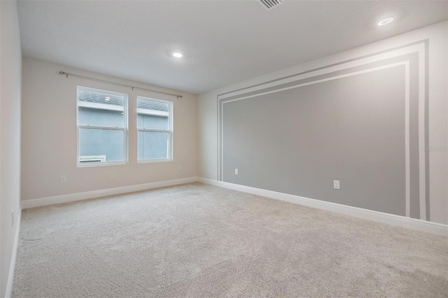 spare room featuring recessed lighting, baseboards, and light colored carpet