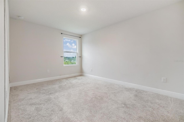 carpeted empty room featuring baseboards