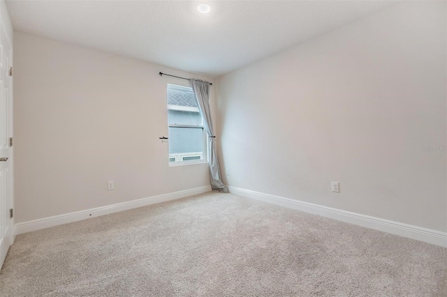 carpeted spare room featuring baseboards