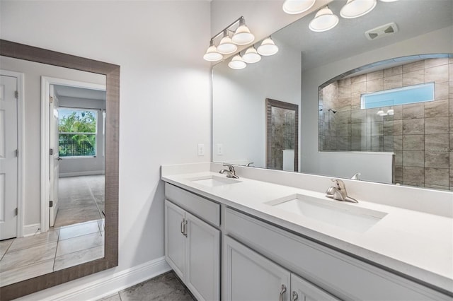 full bath with double vanity, baseboards, walk in shower, and a sink