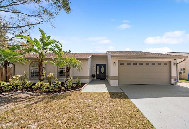 ranch-style house with a garage, concrete driveway, and stucco siding