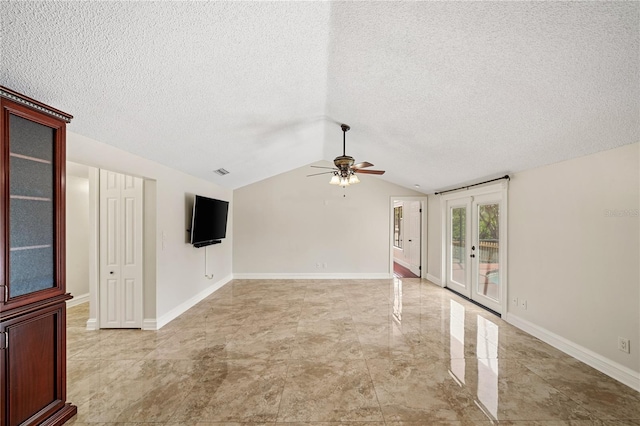 empty room with french doors, a ceiling fan, vaulted ceiling, a textured ceiling, and baseboards