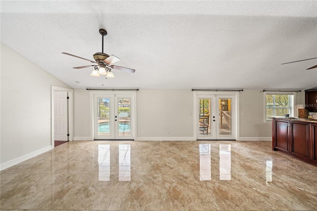 unfurnished living room with baseboards, ceiling fan, marble finish floor, a textured ceiling, and french doors