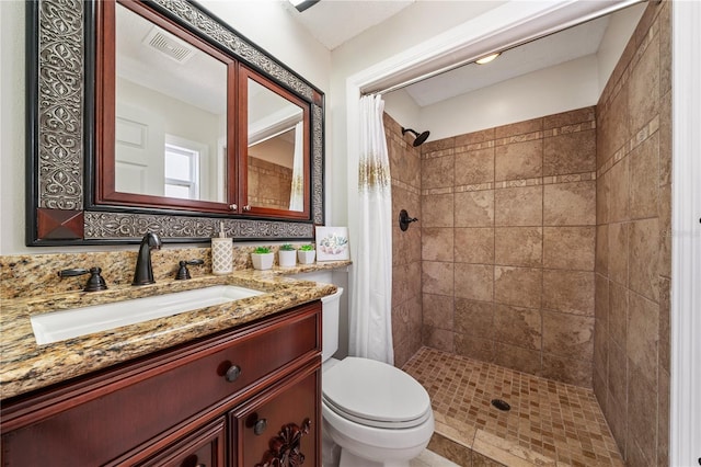 bathroom with visible vents, backsplash, toilet, a shower stall, and vanity