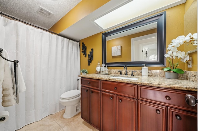 bathroom featuring a textured ceiling, tile patterned flooring, toilet, vanity, and visible vents