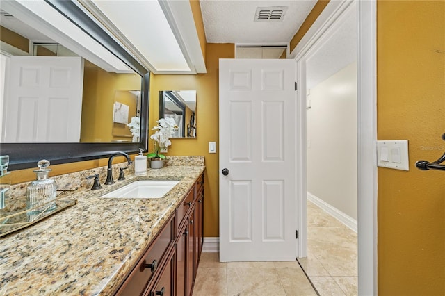 bathroom featuring tile patterned flooring, visible vents, baseboards, and vanity