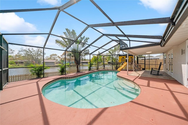 pool featuring a patio, a water view, a lanai, fence, and a playground