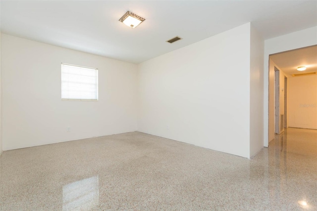 spare room with visible vents and speckled floor