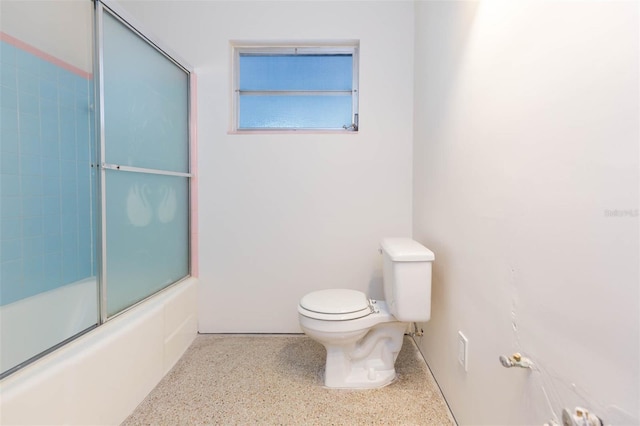 full bath featuring toilet, combined bath / shower with glass door, and speckled floor