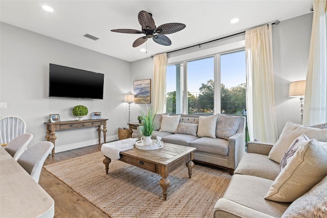 living area with a ceiling fan, wood finished floors, visible vents, and recessed lighting