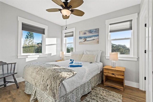 bedroom featuring a ceiling fan, baseboards, and wood finished floors