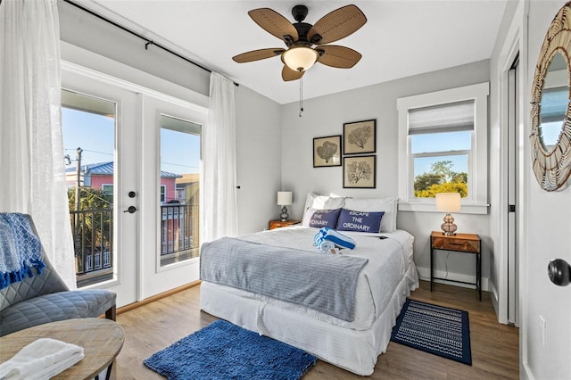 bedroom with access to outside, baseboards, and wood finished floors