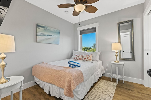 bedroom with a ceiling fan, baseboards, and wood finished floors