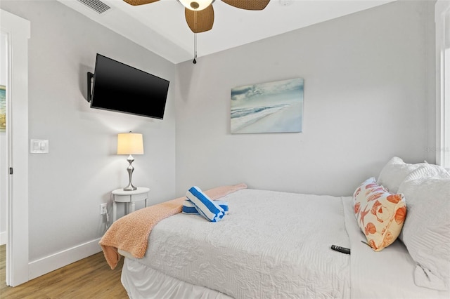 bedroom featuring ceiling fan, wood finished floors, visible vents, and baseboards