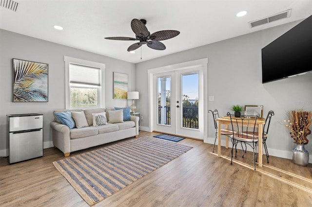 living room with french doors, wood finished floors, visible vents, and baseboards